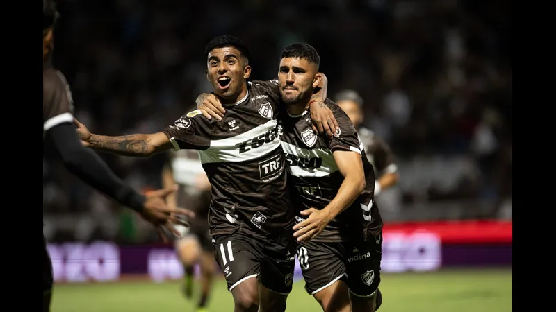 Cầu thủ của Platense đi bóng qua cầu thủ của Deportivo Riestra trong trận đấu bóng đá Cầu thủ của Platense đi bóng qua cầu thủ của Deportivo Riestra trong trận đấu bóng đá